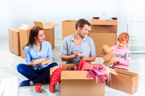 Professional movers carrying household items through a Peckham property